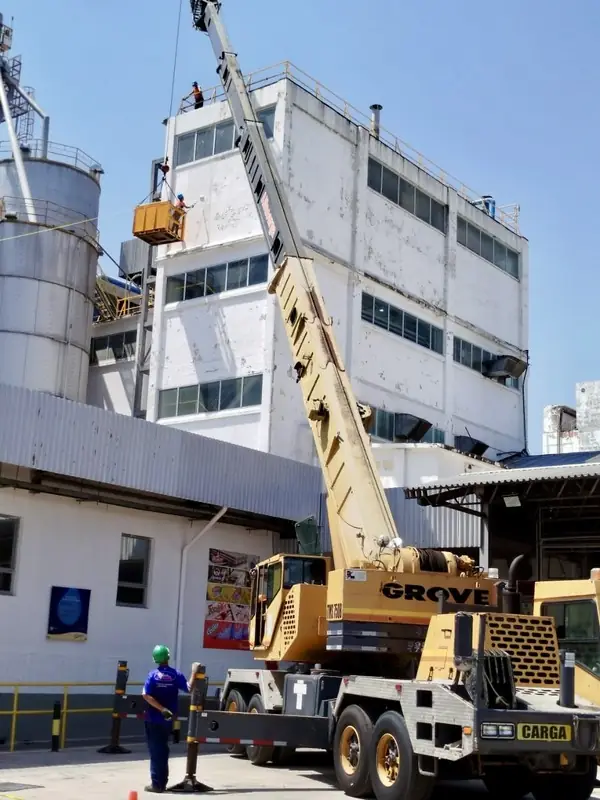 Grúa Grove y cuadrilla en patio de planta industrial