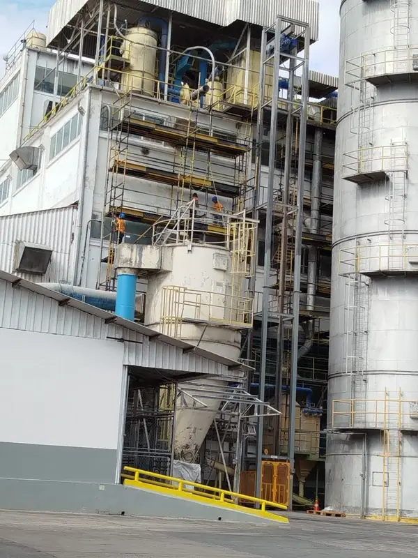 Área de proceso con silos, tuberías y andamios
