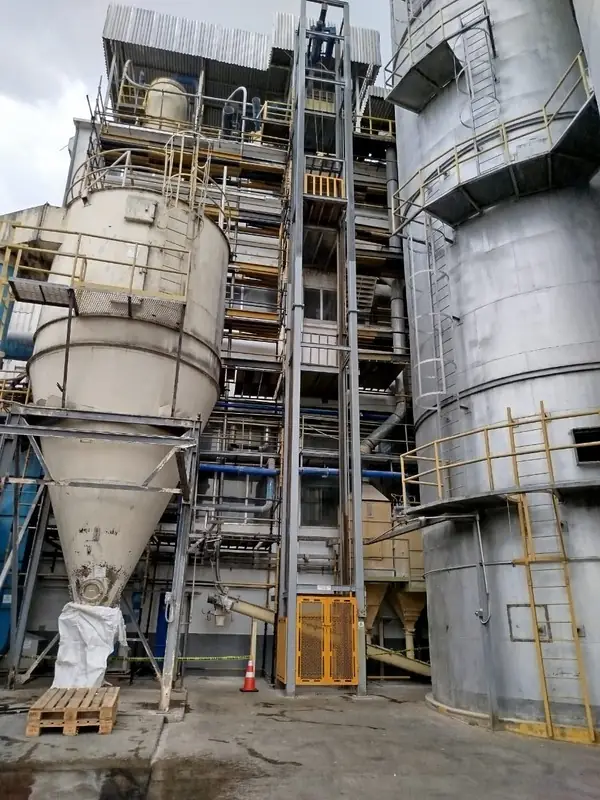Tolvas y silos de planta industrial con andamios de acceso
