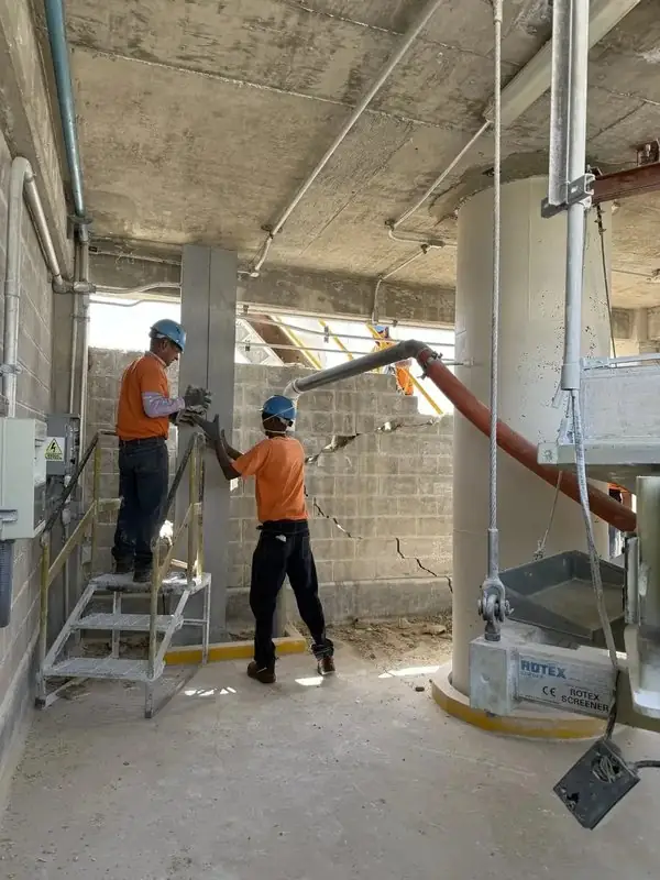Dos obreros trabajando en columnas y mampostería interior de planta