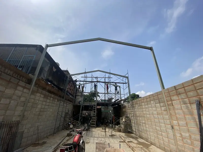 Estructura metálica de galpón con pórtico a dos aguas en montaje